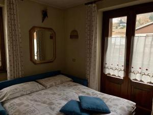 a bedroom with a bed and a window and a mirror at Casa Sosio in Bormio