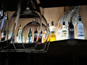 a row of wine glasses on a shelf with wine bottles at Hotel Protea Bolesławiec in Bolesławiec