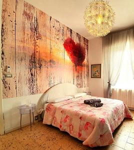 una camera da letto con un letto e un dipinto sul muro di Casa singola a pochi passi dal centro storico a Ravenna
