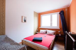 Habitación pequeña con cama roja y ventana en Park & City Alex en Berlín