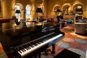 a piano in the middle of a large room at Hotel De Anza, a Destination by Hyatt Hotel in San Jose