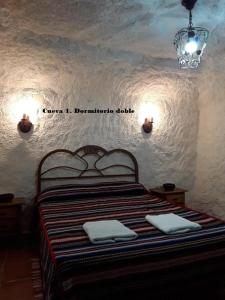 a bedroom with a bed with two towels on it at Cuevas Lourdes in Benamaurel