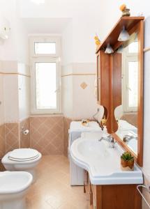 ein Badezimmer mit einem WC, einem Waschbecken und einem Spiegel in der Unterkunft Appartamento al centro di Anzio in Anzio