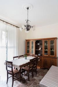 uma sala de jantar com uma mesa e cadeiras e um lustre em Appartamento al centro di Anzio em Anzio