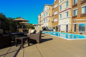 a patio with a table and chairs next to a pool at Staybridge Suites Silicon Valley - Milpitas by IHG in Milpitas