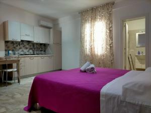 サン・ヴィート・ロ・カーポにあるHoliday Homenzaのベッドルーム(紫色のベッド1台付)、キッチン