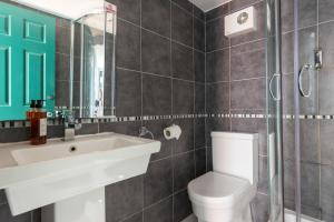 a bathroom with a toilet, sink, and shower at Selina Brighton in Brighton & Hove