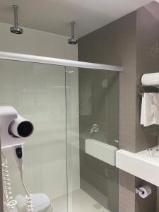 a bathroom with a shower and a glass shower stall at Verona Tower Hotel in Divinópolis