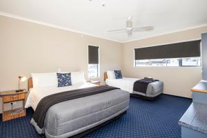 a hotel room with two beds and a television at Bay City Motor Lodge in Timaru