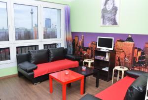 a living room with black leather furniture and a tv at Top View & City ALEX in Berlin