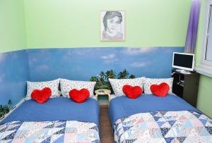 a bedroom with two beds with red heart pillows at SUITE Top View & City Alex 4 rooms 2 bathrooms 1 kitchen in Berlin