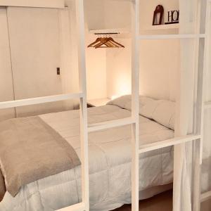 two white bunk beds in a small room at Amplio,cómodo,moderno y céntrico monoambiente. in Paraná