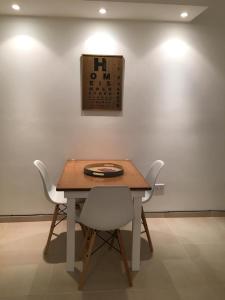 uma mesa e cadeiras num quarto com uma parede em Amplio,cómodo,moderno y céntrico monoambiente. em Paraná