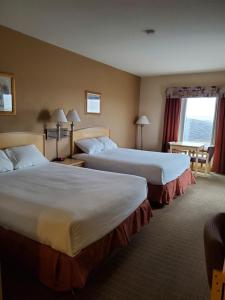 a hotel room with two beds and a window at Lone Star Hotel in North Battleford