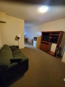 a living room with a couch and a tv at Lone Star Hotel in North Battleford