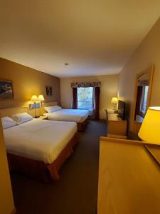 ein Hotelzimmer mit 2 Betten und einem TV in der Unterkunft Lone Star Hotel in North Battleford