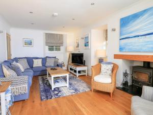 un soggiorno con divano blu e TV di Batson House a Salcombe