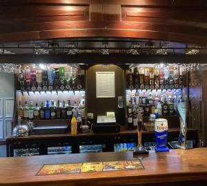 a bar with a lot of bottles of alcohol at Stow Lodge Hotel in Stow on the Wold