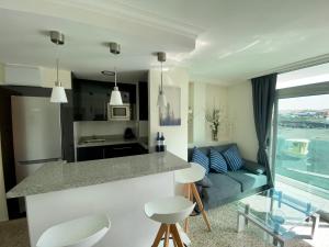 a kitchen and living room with a couch and a counter at Hermoso edificio Frente al mar con gran terraza y hermosas vistas in Las Palmas de Gran Canaria