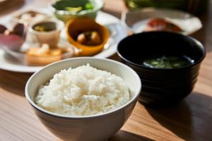 a bowl of rice on a table with plates of food at ANA Crowne Plaza Kanazawa by IHG in Kanazawa