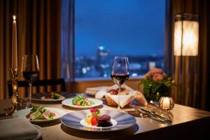 a table with plates of food and a glass of wine at ANA Crowne Plaza Kanazawa by IHG in Kanazawa
