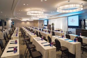 a banquet hall with white tables and chairs and a screen at ANA Crowne Plaza Kanazawa by IHG in Kanazawa
