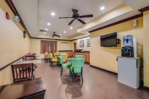 una sala de espera con mesas, sillas y TV en Econo Lodge Inn & Suites Little Rock SW, en Little Rock