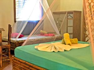1 Schlafzimmer mit 2 Etagenbetten mit ausgestopften Tieren auf dem Bett in der Unterkunft Cascada Verde Hostel in Uvita