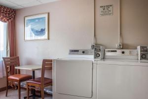 a kitchen with a refrigerator and a table with chairs at Comfort Inn & Suites near Kino Sports Complex in Tucson