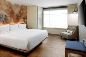a room with a bed, chair, and a window at Cambria Hotel Phoenix Chandler - Fashion Center in Chandler