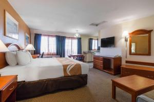 Quality Inn & Suites Crescent City Redwood Coast في كريسنت سيتي: غرفه فندقيه سرير كبير وتلفزيون