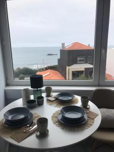 a table with plates and utensils on it with a window at Porto Beach Rooms in Porto