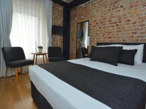 a bedroom with a bed and a brick wall at Taxim No18 Boutique Hotel in Istanbul
