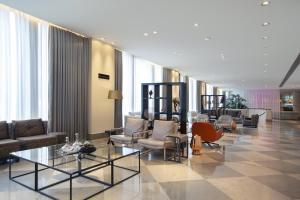 a living room filled with furniture and a large window at Crowne Plaza Berlin - Potsdamer Platz, an IHG Hotel in Berlin