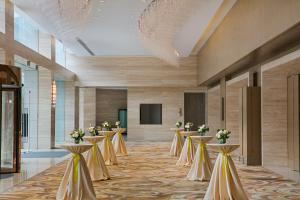 a row of tables in a lobby with flowers on them at Crowne Plaza Zhongshan Wing On City by IHG in Zhongshan