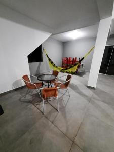 Habitación con mesa, sillas y hamaca. en Casa FLORIANÓPOLIS, Praia de PONTA DAS CANAS,2, en Florianópolis