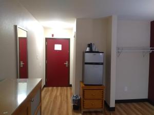 a kitchen with a refrigerator and a red door at Red Crown Inn in Laurel