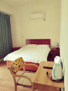 una habitación de hotel con una cama y una mesa con una mesa en 星海芝家民宿Samuel's Home, en Nangan