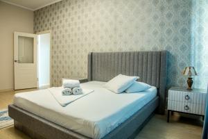 ein Schlafzimmer mit einem Bett mit zwei Handtüchern darauf in der Unterkunft Апартаменты #89 в ЖК Zaman in Atyrau