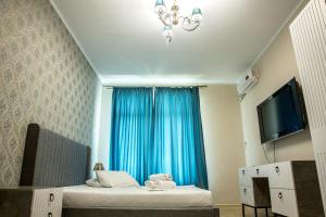 Zimmer mit einem Bett und einem blauen Fenster in der Unterkunft Апартаменты #89 в ЖК Zaman in Atyrau