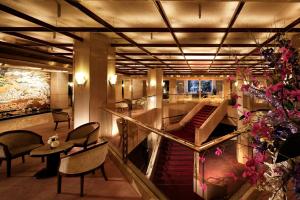 a lobby with stairs and a table and chairs at ANA Crowne Plaza Hotel Kyoto by IHG in Kyoto