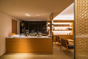 a kitchen with a counter and chairs in a room at ANA Crowne Plaza Hotel Kyoto by IHG in Kyoto