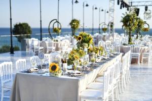 a long table with white chairs and tables with flowers at Crowne Plaza Florya Istanbul by IHG in Istanbul
