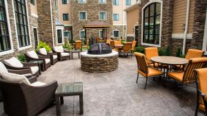 a patio with chairs and tables and a fire pit at Staybridge Suites Lexington by IHG in Lexington
