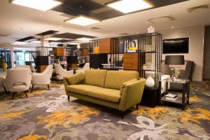 a library with a couch and chairs in a room at Crowne Plaza Basingstoke by IHG in Basingstoke