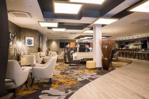 a lobby with a waiting area with chairs and tables at Crowne Plaza Basingstoke by IHG in Basingstoke