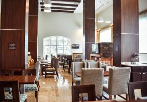 a dining room with tables and chairs and a unintention at Staybridge Suites Puebla by IHG in Puebla