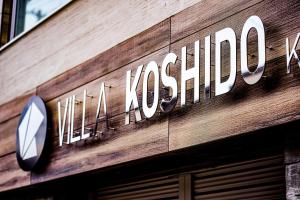 VILLA KOSHIDO KOTONI annex في سابورو: علامة على جانب المبنى