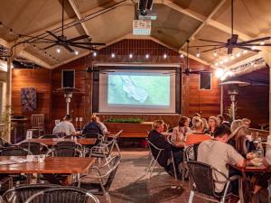 a crowd of people sitting in a restaurant watching a presentation at Telegraph Hotel Numurkah in Numurkah