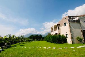 順安村的住宿－後山城寶民宿，一座建筑旁边草场的建筑